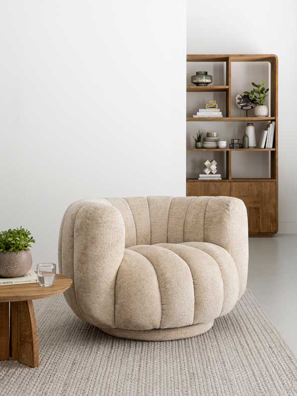 MUST Living Mello fauteuil in cr&egrave;me met een houten kast en bijzettafel in een lichte zithoek